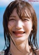 A woman with wet hair smiles at the camera.