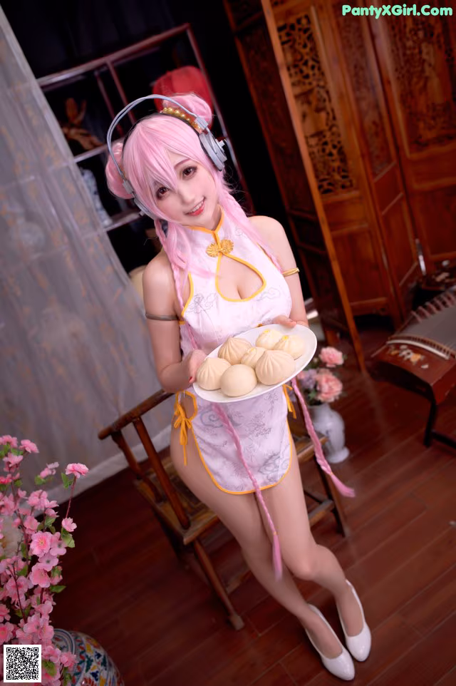 A woman in a pink dress holding a plate of food.