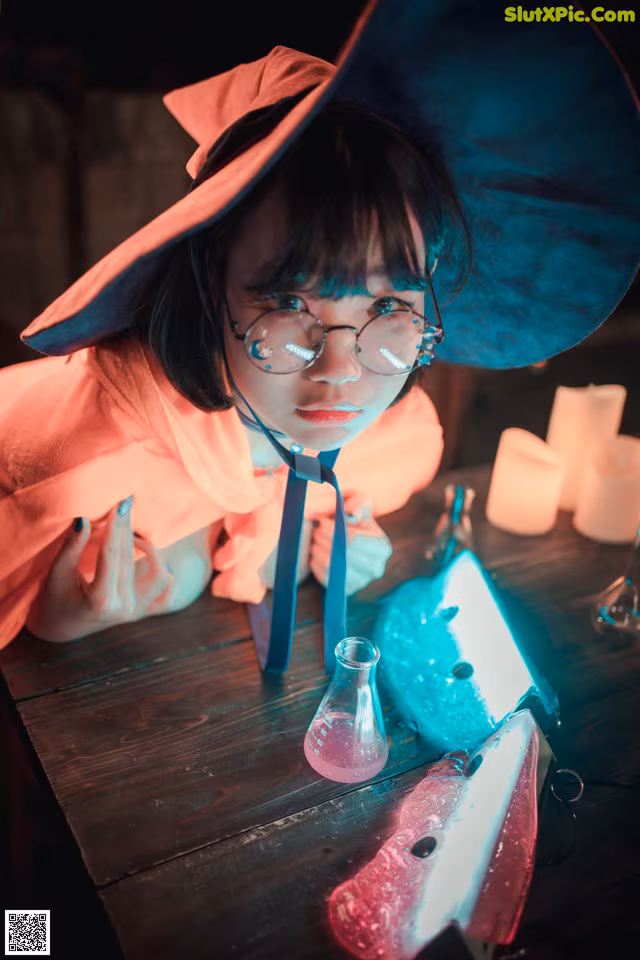 A little girl wearing a witch hat and glasses.