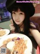 A woman sitting at a table with a plate of food.